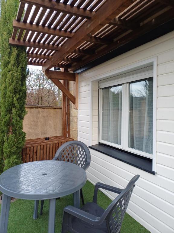 a patio with a table and chairs and a window at Ambiance chalet in Prignac-et-Marcamps