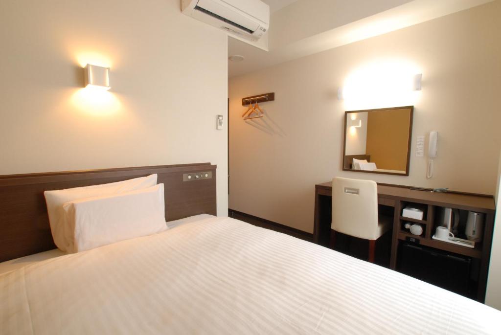 Postel nebo postele na pokoji v ubytování AB Hotel Kanazawa