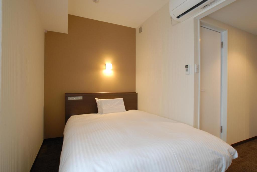 Postel nebo postele na pokoji v ubytování AB Hotel Kanazawa