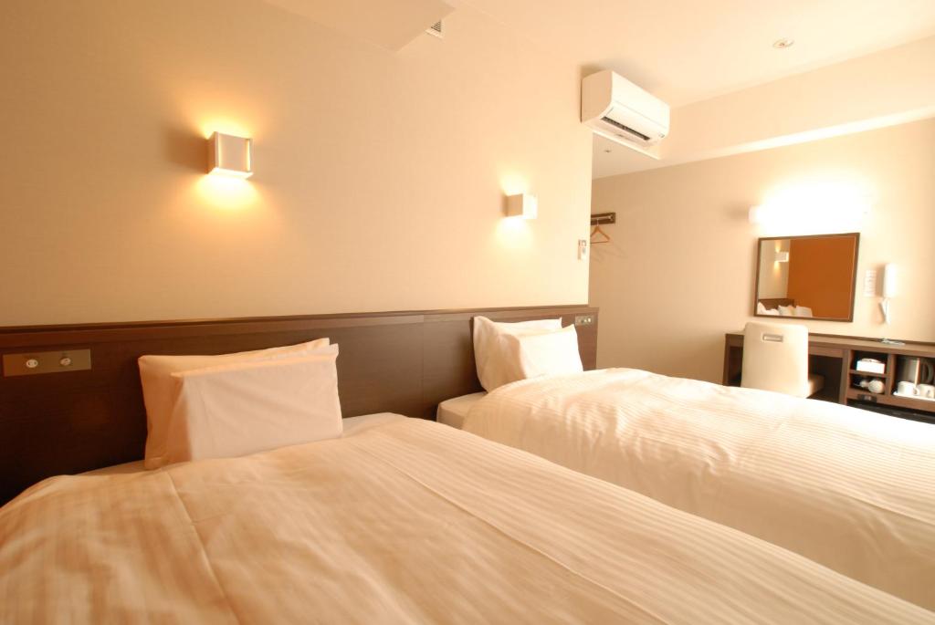 Postel nebo postele na pokoji v ubytování AB Hotel Kanazawa