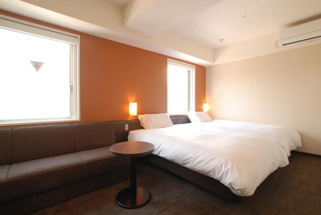 Postel nebo postele na pokoji v ubytování AB Hotel Kanazawa