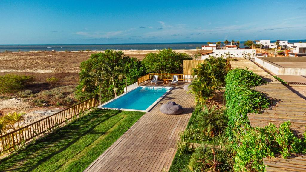 una piscina en una terraza con la playa en Santa Maria Inn, en São Miguel do Gostoso