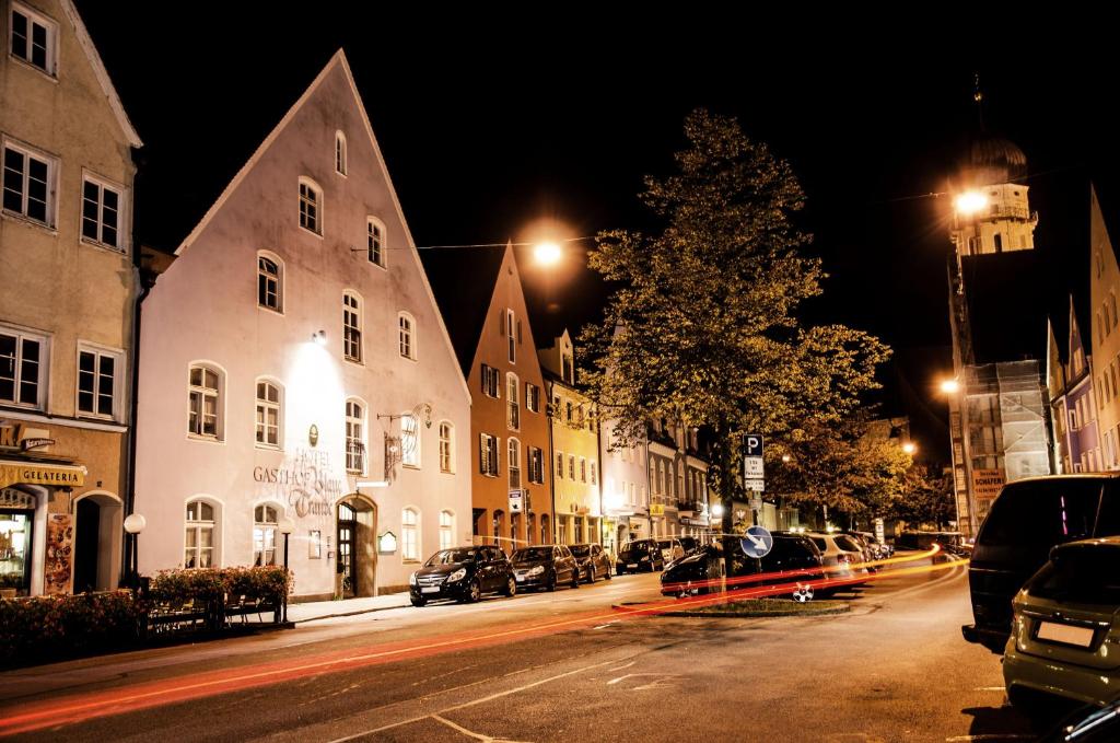 a city street at night with cars parked on the side of the street at Hotel Blaue Traube in Schongau