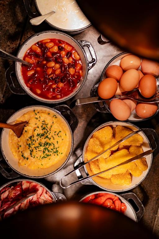 a table topped with bowls of different types of food at Don Giovanni Hotel Prague - Great Hotels of The World in Prague