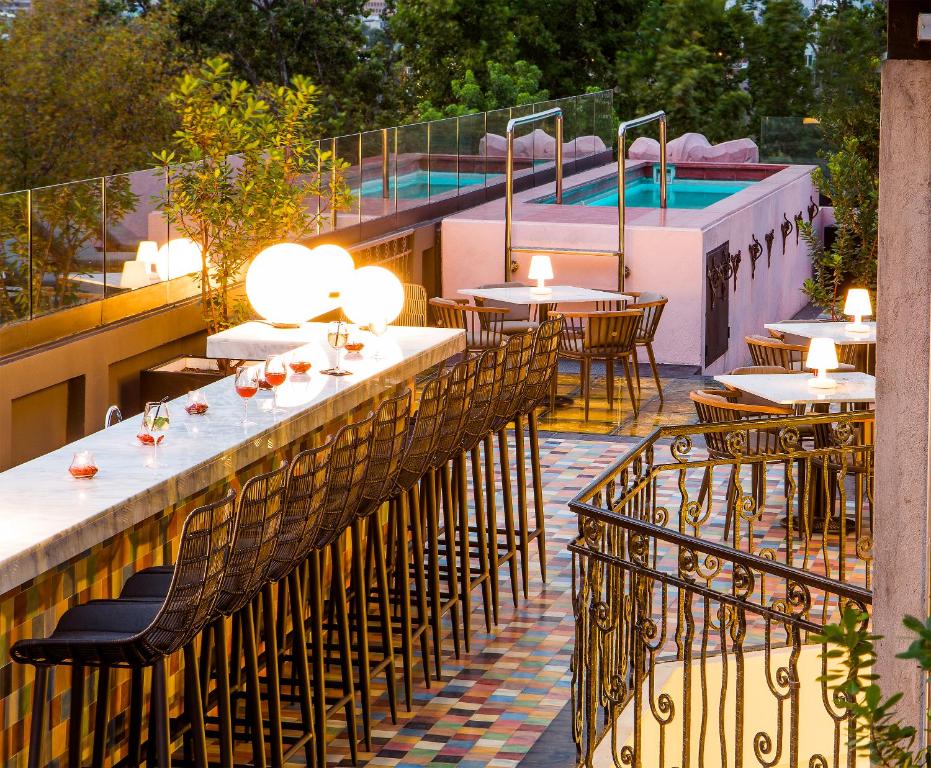un restaurante con mesas y sillas y una piscina en Hotel Luciano K, en Santiago