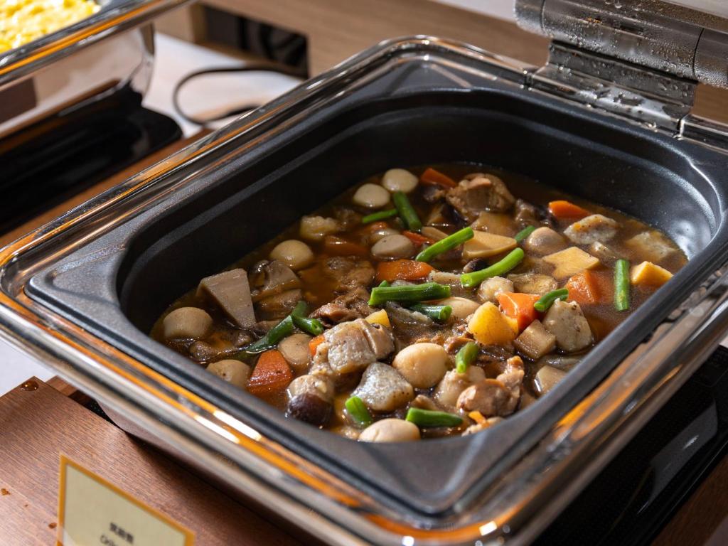 a dish of food with meat and vegetables at SUPER HOTEL Ikebukuro West Natural Hot Spring in Tokyo