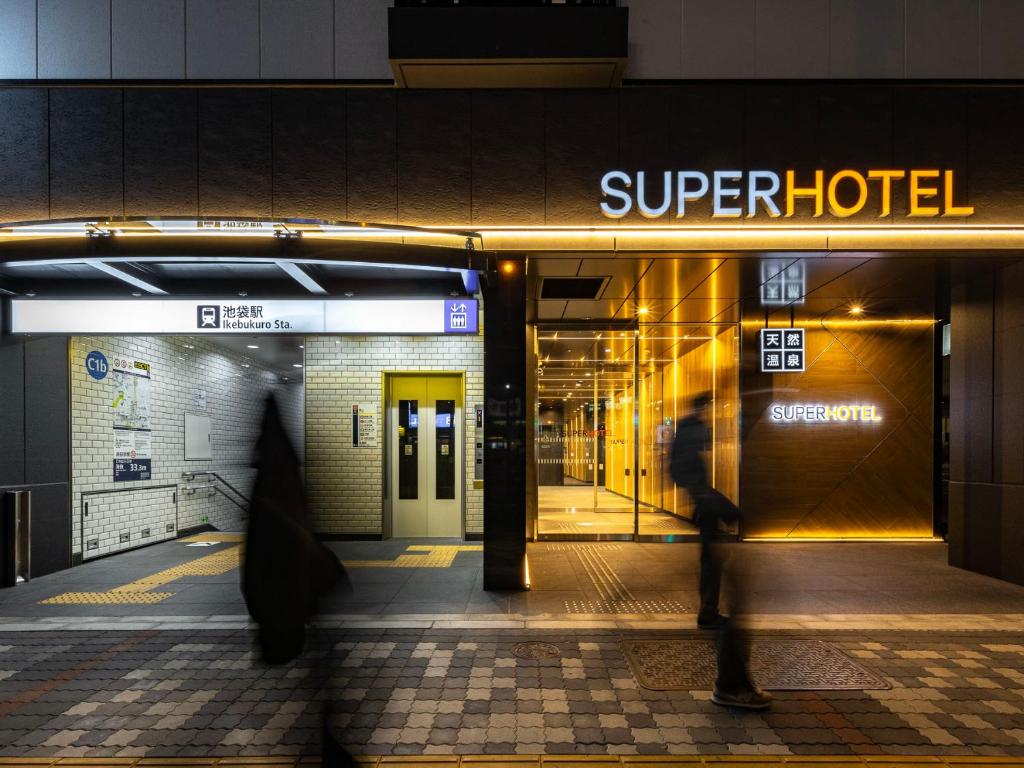 a person walking in front of a hotel at SUPER HOTEL Ikebukuro West Natural Hot Spring in Tokyo