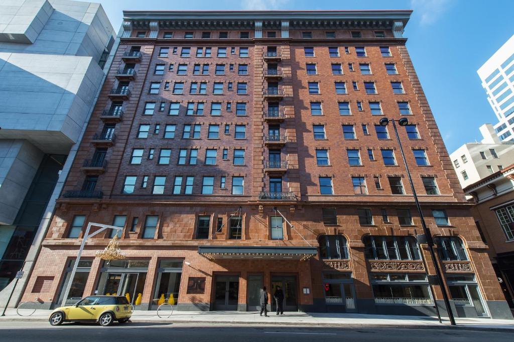 a yellow car parked in front of a brick building at 21c Museum Hotel Cincinnati in Cincinnati