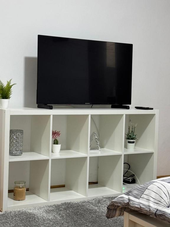 a white entertainment center with a television on it at National Stadium Aparment in Bucharest