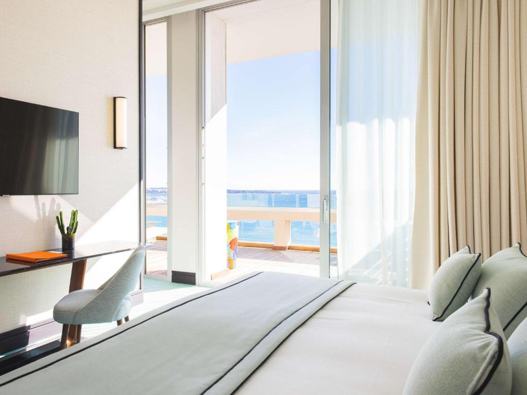 a bedroom with a bed with a view of the ocean at Mondrian Cannes in Cannes
