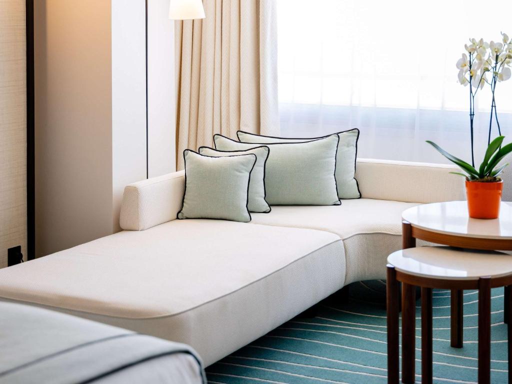 a white couch in a room with a window at Mondrian Cannes in Cannes