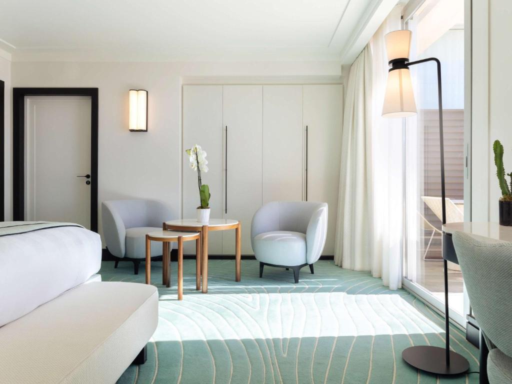 a living room with a bed and a table and chairs at Mondrian Cannes in Cannes