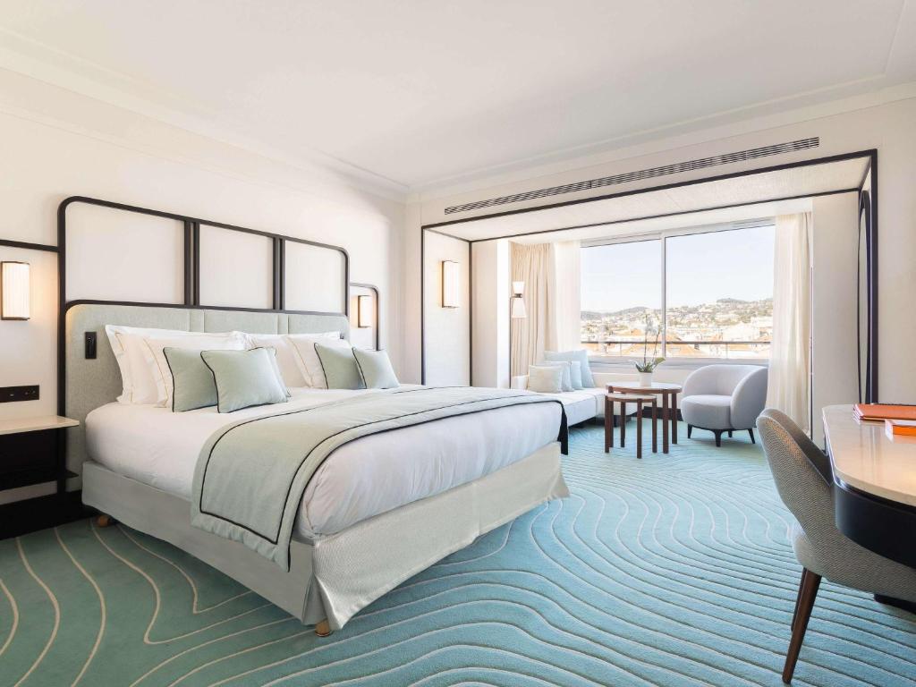 a hotel room with a large bed and a desk at Mondrian Cannes in Cannes