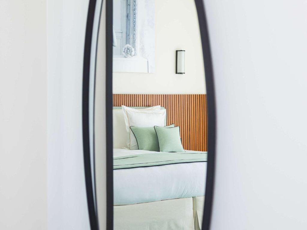 a mirror reflection of a bed in a room at Mondrian Cannes in Cannes