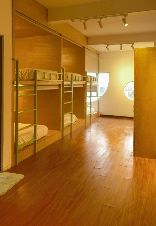 岘港Leaf Sustainable Hostel的一间铺有木地板的带双层床的房间