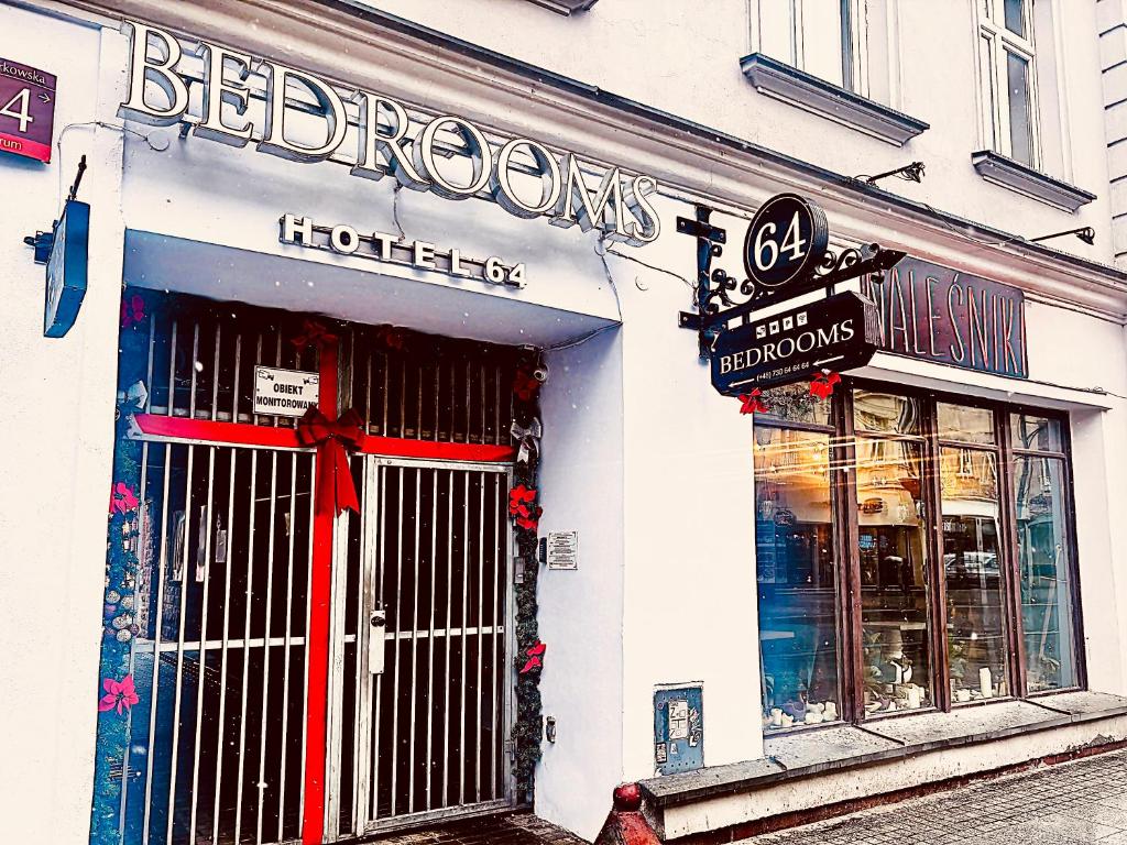 a store with a sign on the front of a building at BedRooms Piotrkowska 64 in Łódź