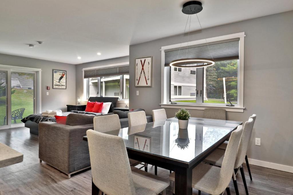 una sala da pranzo e un soggiorno con tavolo e sedie di Spacious 2RM-2BA Condo in the Heart of the Town, Summer Pool, Shuttle Route a Killington