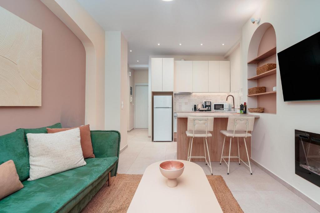 un soggiorno con un divano verde e una cucina di Koukaki Jacuzzi Retreat ad Atene