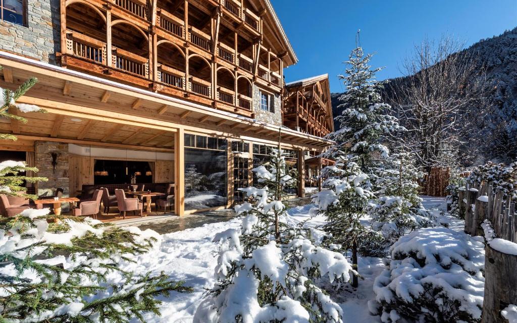 a lodge in the snow with a christmas tree at Naturhotel Lüsnerhof in Luson