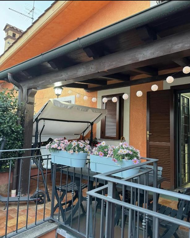 a patio with a table with flowers on it at Luce - Pantano metro C in Osteria dellʼ Osa