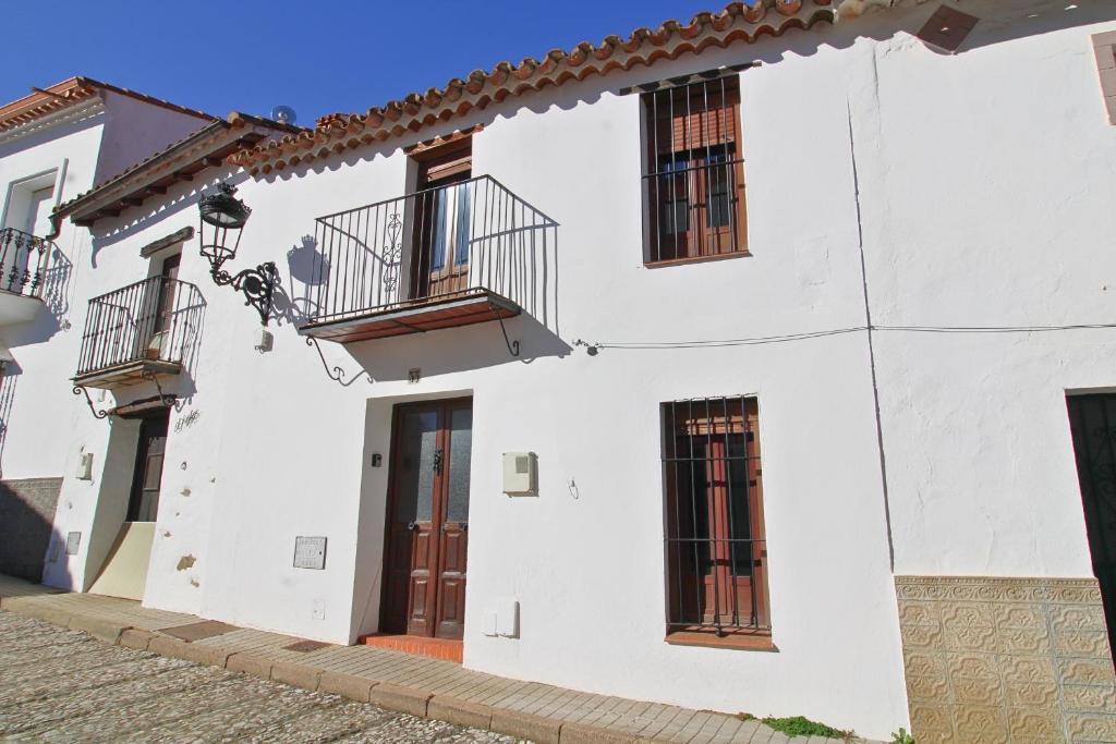 ein weißes Gebäude mit zwei Balkonen darauf in der Unterkunft La Casa de la Tierra by SIERRA VIVA in Los Marines
