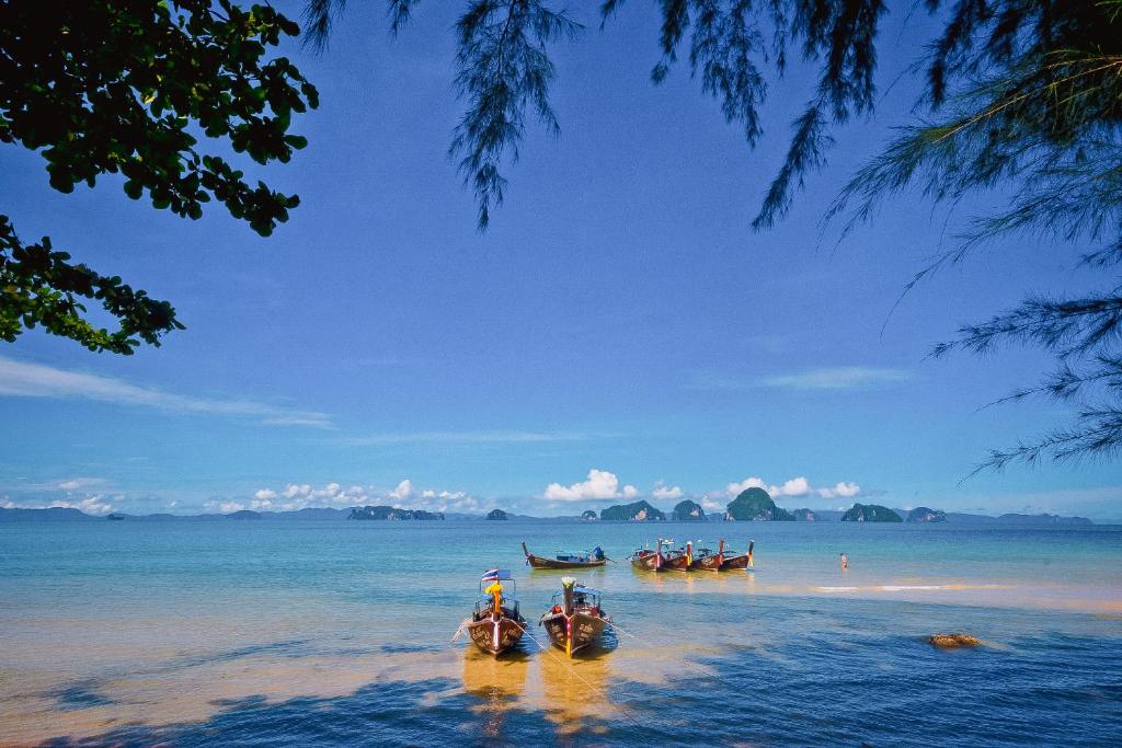 a group of boats in the water on a beach at Anyavee Tubkaek Beach Resort in Tab Kaek Beach