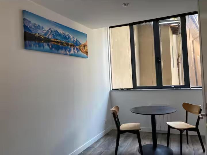 a room with a table and two chairs and a window at studio centre-ville historique in Chambéry