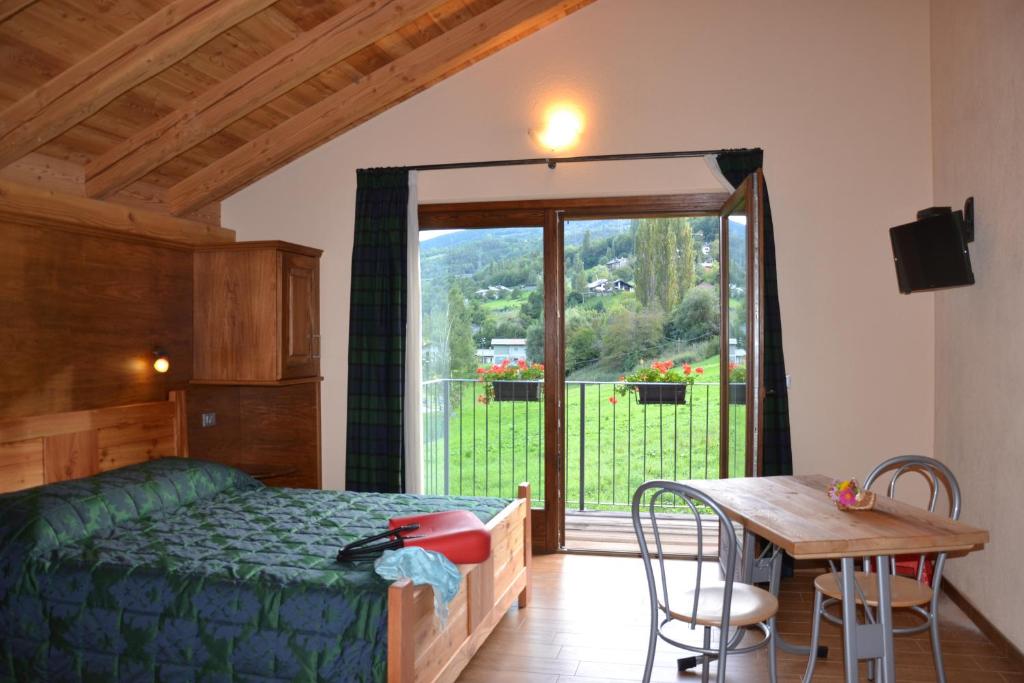 a bedroom with a bed and a table and a window at Village Paradis in Roisan
