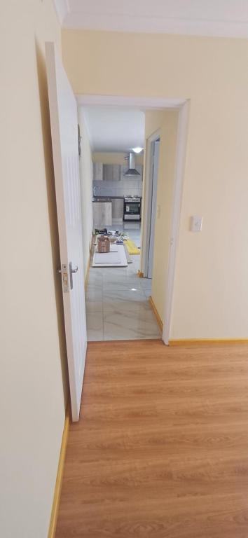 una habitación vacía con un pasillo que conduce a una cocina en Cosy Cove, en Grassy Park