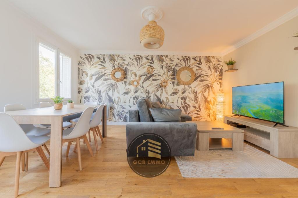 un salon avec une table et une télévision dans l'établissement L'Europole - 3 chambres proche gare, à Grenoble