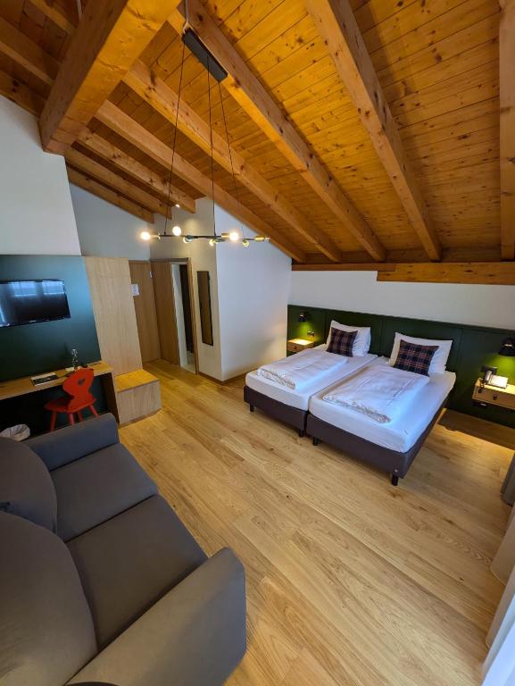 a large bedroom with a bed and a couch at Hotel Sonnwendhof Engelberg in Engelberg