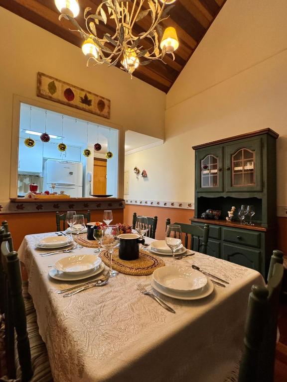 a dining room table with plates and wine glasses at Apartamentos Centrinho Capivari - Recanto Boticário in Campos do Jordão