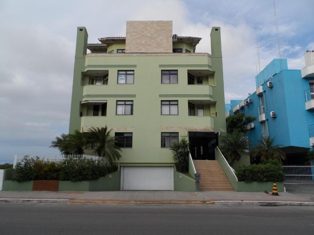 un edificio verde con una torre encima en Apartamento Ilhas Do Norte, en Florianópolis