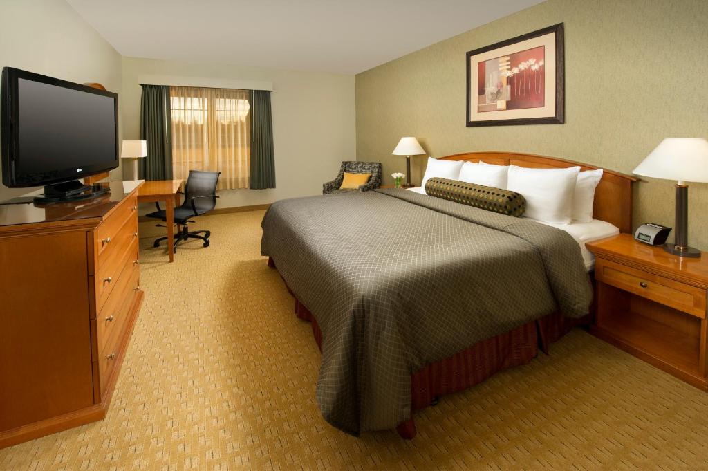 a hotel room with a bed and a flat screen tv at Redmond Inn in Redmond