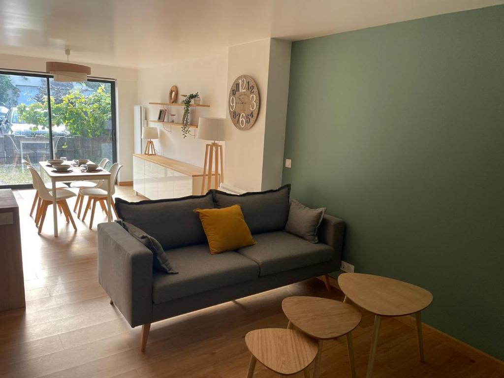 een woonkamer met een bank en een tafel bij Appartement 15 min Disney Paris in Coutevroult