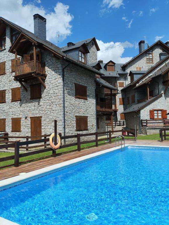 a resort with a swimming pool in front of a building at El rincón de Benás in Anciles