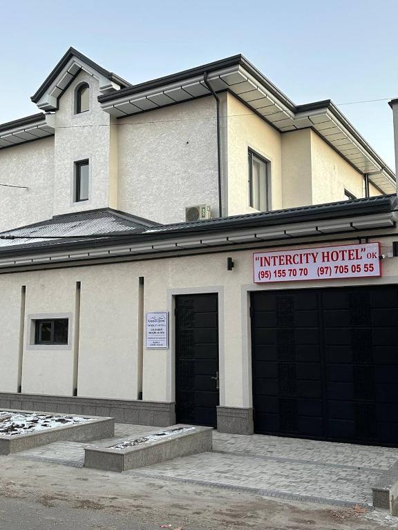 a building with two garage doors and a sign on it at Intercity Hotel Tashkent by Maskan in Tashkent