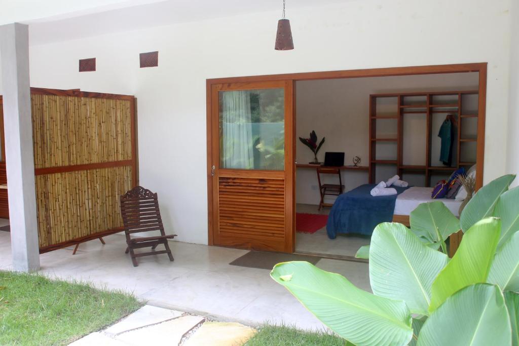 a bedroom with a bed and a desk and a chair at Moksha Surf Yoga in Ubatuba