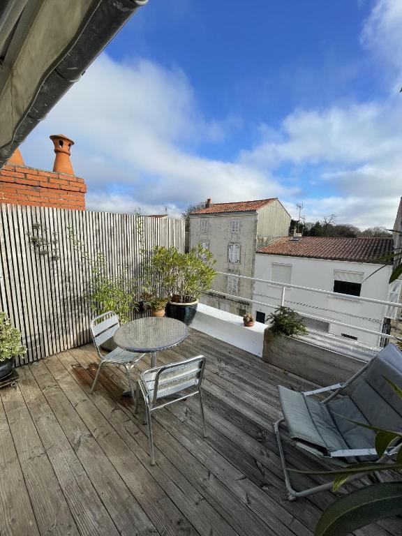 a patio with a table and chairs on a deck at Maison de ville avec terrasse in La Rochelle