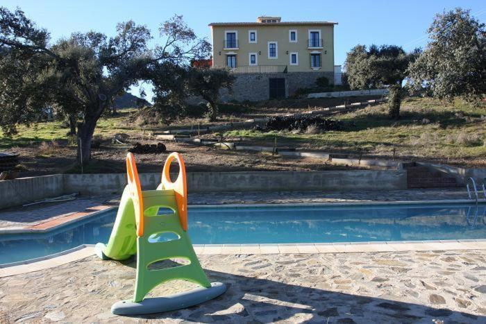 El Hoyo的住宿－Cortijo El Criadero，游泳池旁的儿童游乐场设备