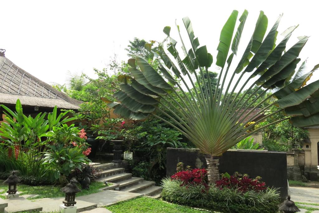 uma palmeira no meio de um jardim em Villa Nirvana em Ubud