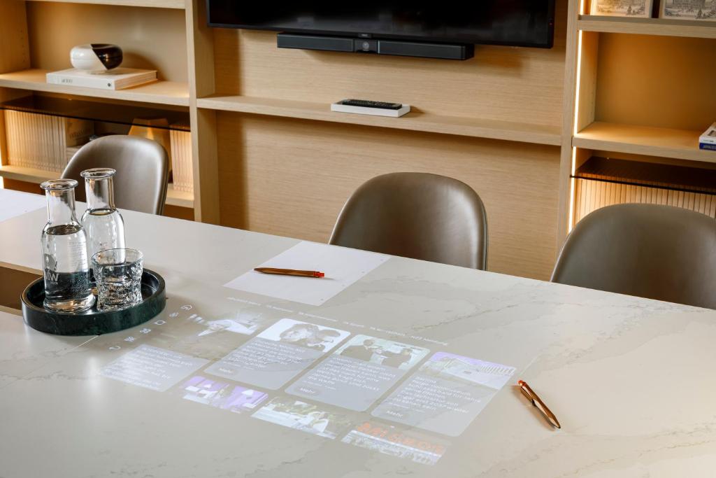 a table with bottles and glasses on it with chairs at Small Luxury Hotel Ambassador Zurich in Zürich