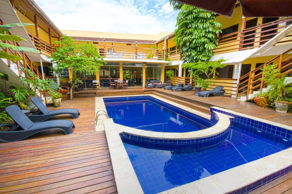 uma piscina no meio de uma casa em Flat Vila Morena a pousada da sua família em Camburi