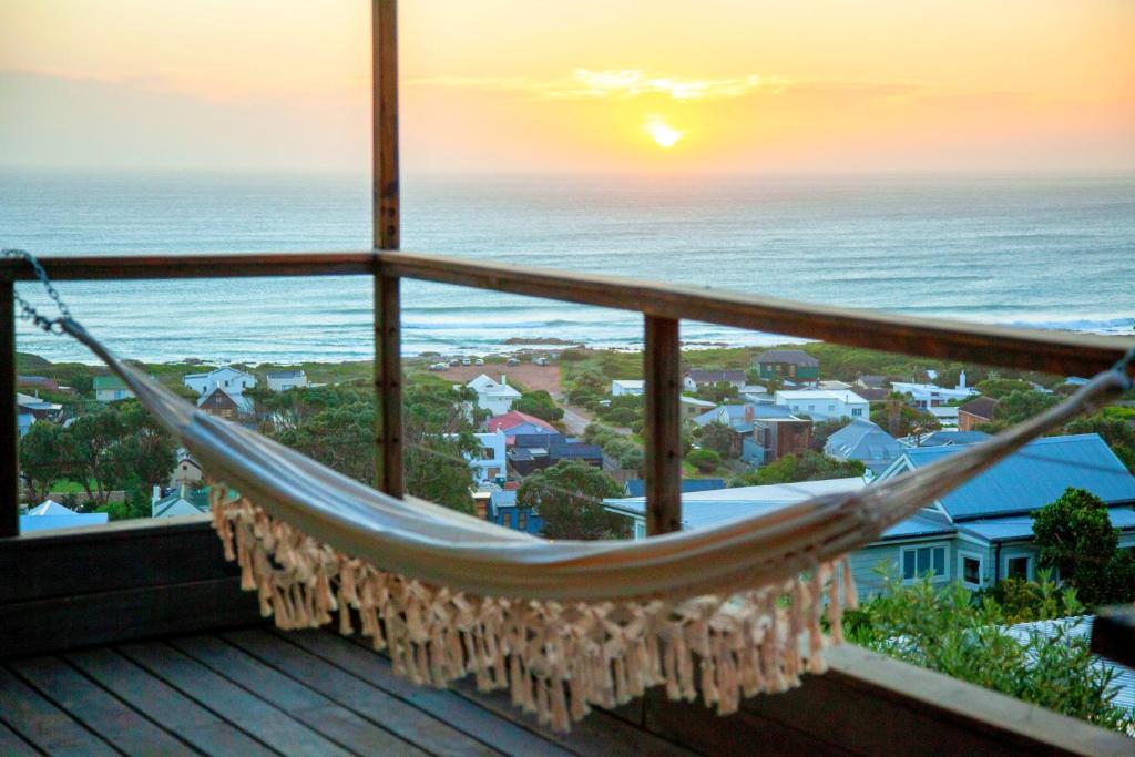 a hammock on a balcony with a view of the ocean at Sunset Villa in Scarborough