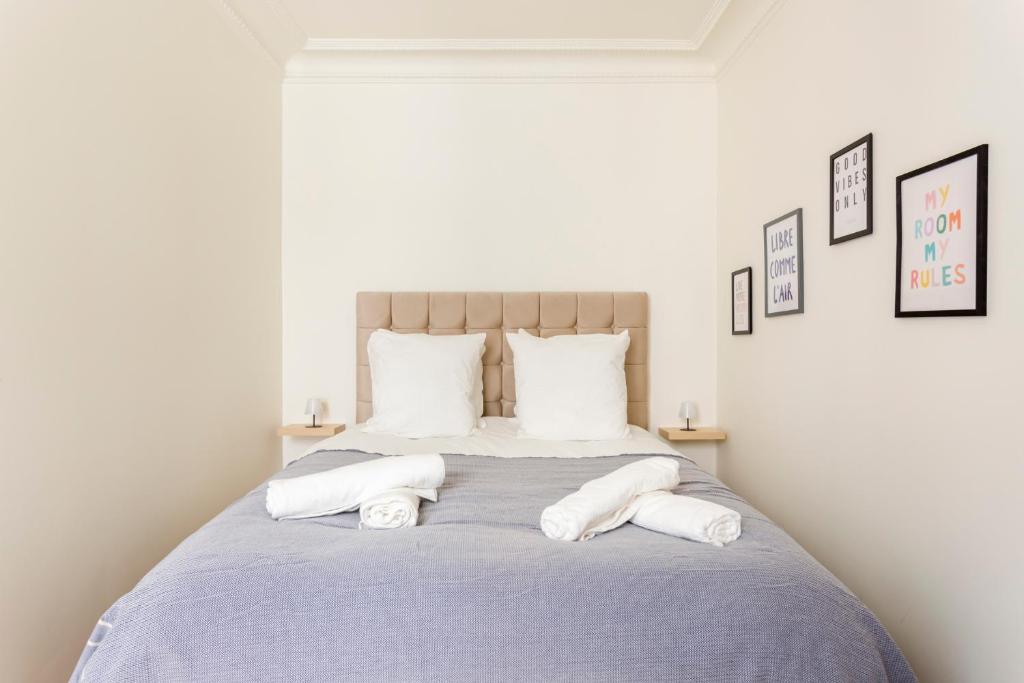une chambre avec un lit avec deux serviettes dessus dans l'établissement Superbe appartement Montmartre, à Paris