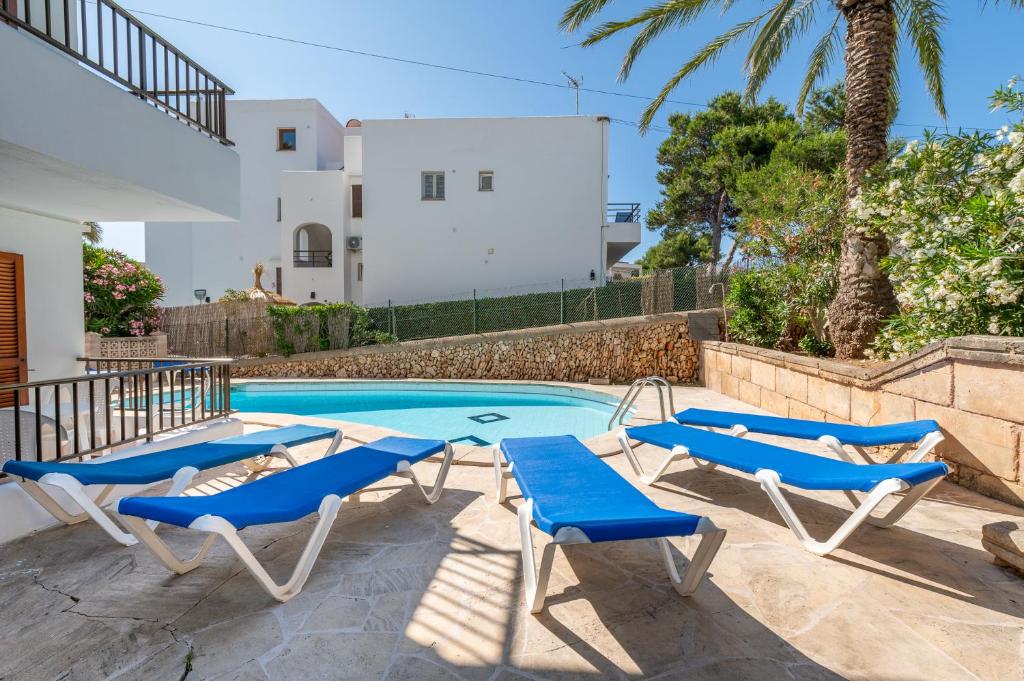 a swimming pool with blue lounge chairs and a swimming pool at Gran Sol Family 7 in Felanitx