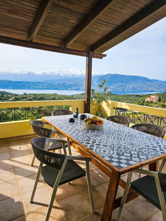 a table and chairs on a patio with a view at Villa Aitheras with sea views and garden in Stérnai