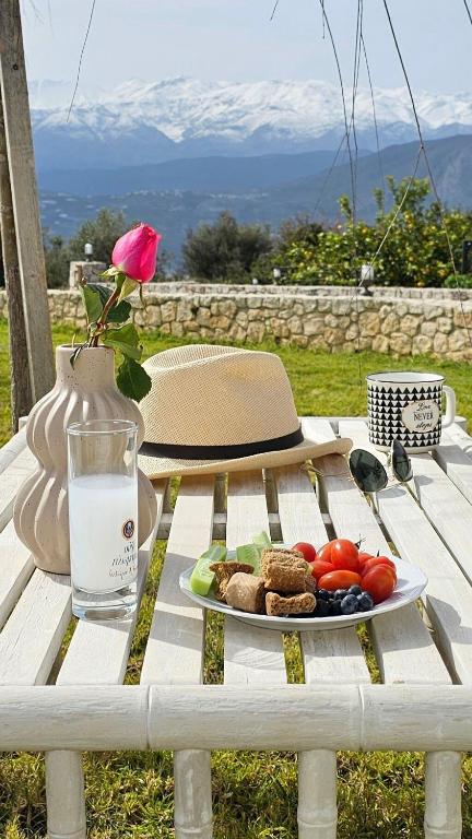 a picnic table with a plate of food and a glass of water at Villa Aitheras with sea views and garden in Stérnai