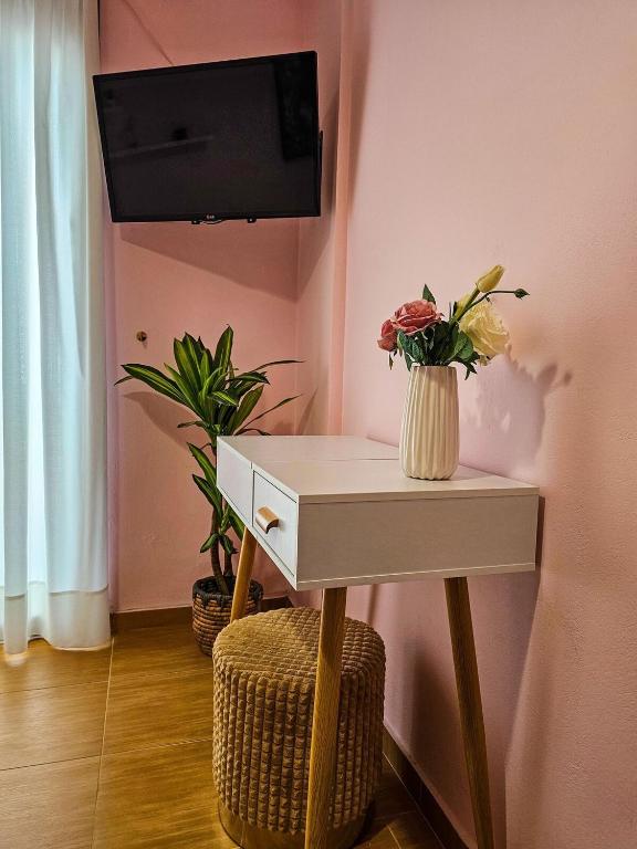 a white table with a vase of flowers on a wall at Villa Aitheras with sea views and garden in Stérnai
