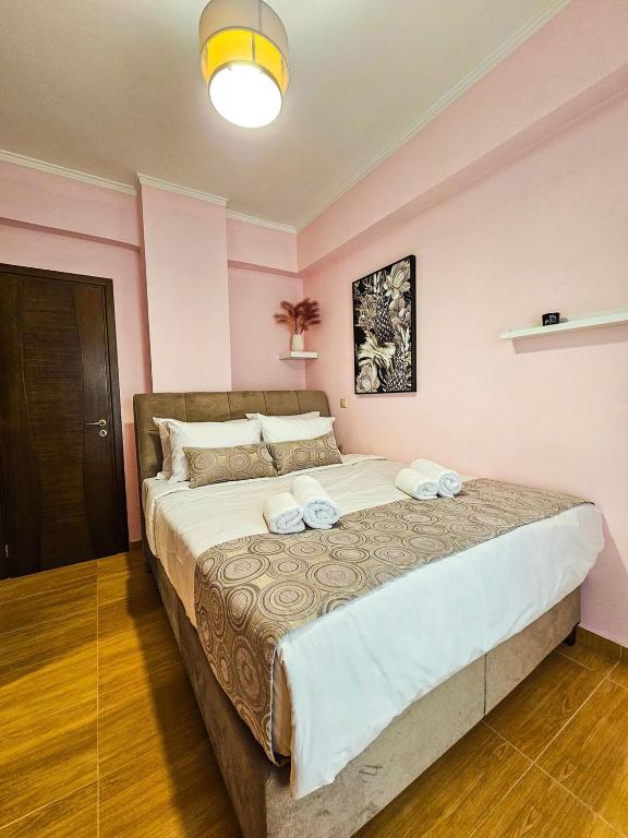 a large bed in a room with pink walls at Villa Aitheras with sea views and garden in Stérnai